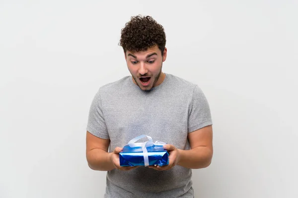 Homme Aux Cheveux Bouclés Sur Mur Isolé Tenant Boîte Cadeau — Photo