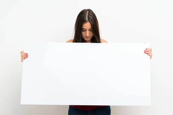 年轻女子在孤立的白色背景拿着一个空的白色标语牌插入一个概念 — 图库照片