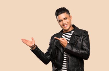 İzole arka plan üzerinde bir reklam eklemek için avuç içinde copyspace hayali tutan genç adam