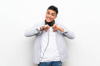 Kulaklıklı izole beyaz duvar üzerinde genç adam gurur ve kendini tatmin