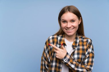 Mavi duvarın üzerinde parmak yan gösteren genç kadın