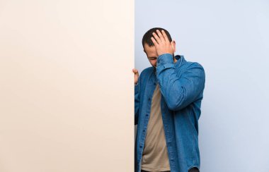 Boş bir plasard tutan Kolombiyalı adam yüz ifadesi karıştırır ile şüpheler