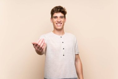 Izole arka plan üzerinde yakışıklı genç adam gelmeye davet