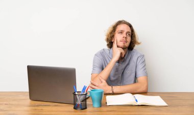 Yukarı bakarken bir fikir düşünme bir dizüstü bilgisayar ile Sarışın adam