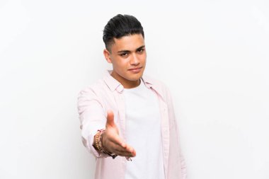 Iyi bir anlaşma sonra izole beyaz duvar handshake üzerinde genç adam