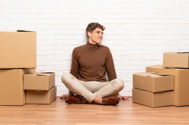 Yakışıklı genç adam yan arayan kutular arasında yeni bir evde hareket