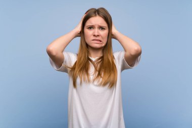 Genç kadın mavi duvarın üzerinden alır eller başının üstüne çünkü migren vardır