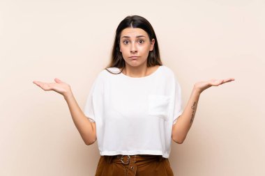 El kaldırırken şüpheleri olan izole arka plan üzerinde genç esmer kadın