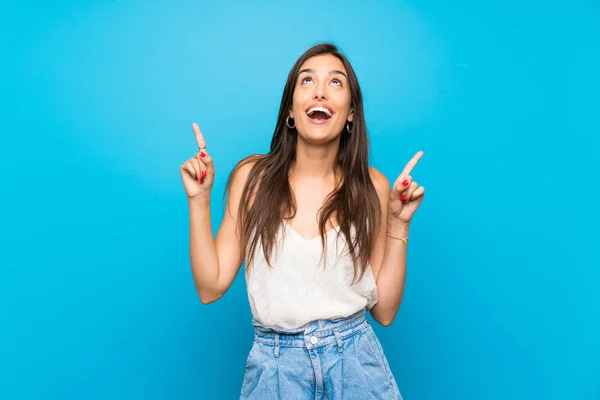 Giovane Donna Isolato Sfondo Blu Sorpreso Puntando Verso Alto — Foto Stock