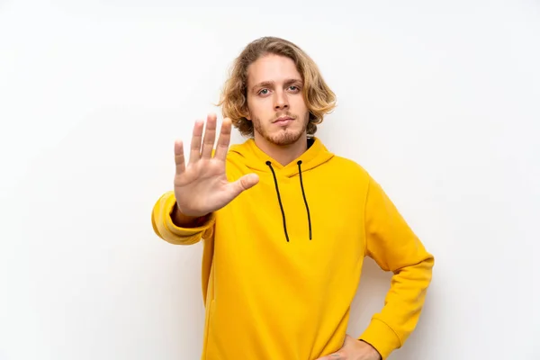 Blond Man Med Sweatshirt Över Vit Vägg Göra Stopp Gest — Stockfoto