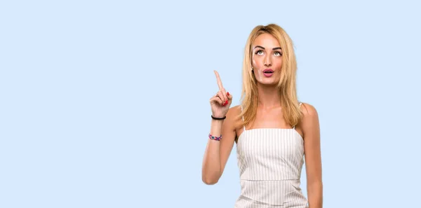 Genç Sarışın Kadın Izole Mavi Arka Plan Üzerinde Parmak Işaret — Stok fotoğraf