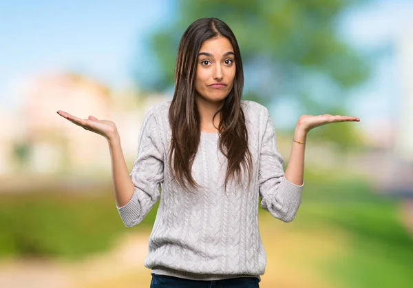 Young Hispanic Brunette Woman Having Doubts While Raising Hands Outdoors — Stock Photo, Image