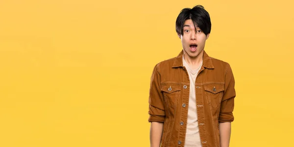Asian Man Brown Jacket Surprise Facial Expression Isolated Yellow Background — Stock Photo, Image