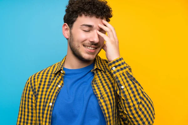 Człowiek Kręconymi Włosami Kolorowej Ścianie Śmiechu — Zdjęcie stockowe