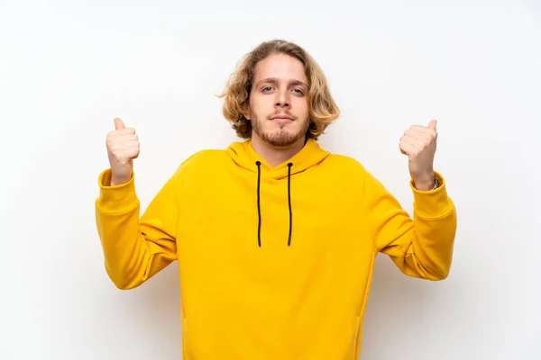 Blond Man Med Sweatshirt Över Vit Vägg Med Tummen Upp — Stockfoto