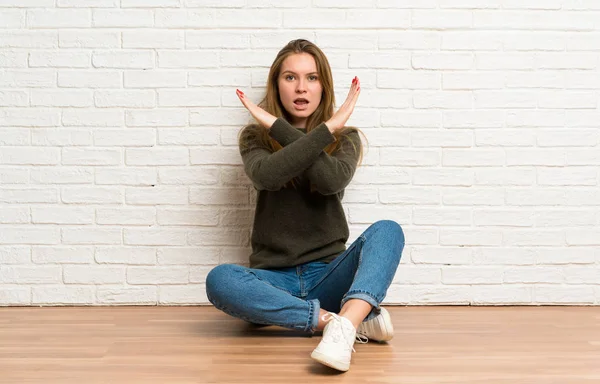 Junge Frau Sitzt Auf Dem Boden Und Macht Keine Geste — Stockfoto