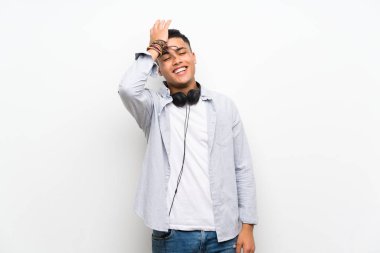 Kulaklıkile izole beyaz duvar üzerinde genç adam bir şey fark etti ve çözüm niyetinde