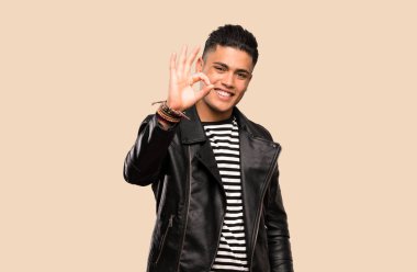 İzole arka plan üzerinde parmakları ile ok işareti gösteren genç adam