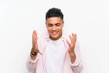 Genç adam üzerinde izole beyaz duvar gülüyor