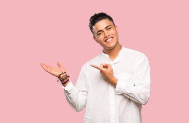 Renkli arka plan üzerinde bir reklam eklemek için avuç üzerinde copyspace hayali tutan genç adam