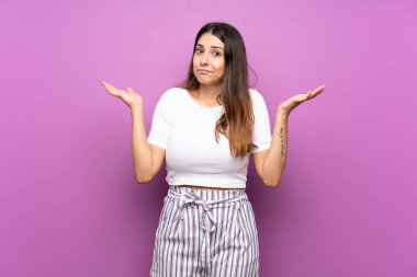 Soyutlanmış mor arka plan kuşkulu hareketler yapan genç bir kadın.