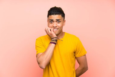 Izole pembe duvar sinirli ve korkmuş üzerinde sarı gömlekli genç adam