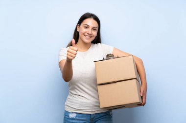 Iyi bir şey oldu çünkü başparmak ile mavi tuğla duvar üzerinde genç teslimat kadın