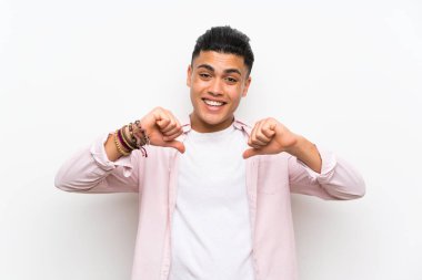 Izole beyaz duvar üzerinde genç adam gururlu ve kendini tatmin