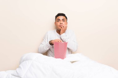 Patlamış mısırile yatakta genç adam