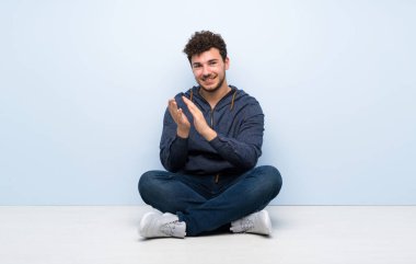 Bir konferansta sunum sonra alkışlamak yerde oturan genç adam