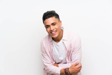 Genç adam üzerinde izole beyaz duvar gülüyor