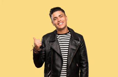 Genç adam izole arka plan üzerinde bir ürün sunmak için yan işaret