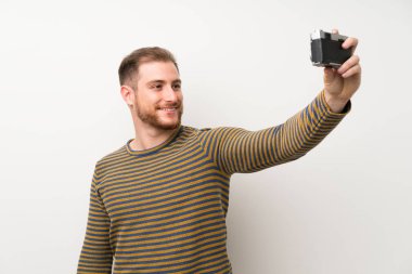 Izole beyaz duvar üzerinde yakışıklı adam selfie yapıyor