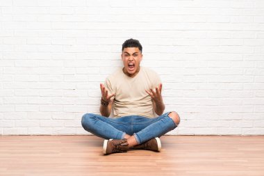 Genç adam katta mutsuz ve bir şey ile sinirli oturan