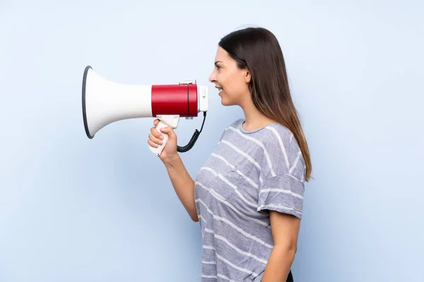 Jonge Brunette Vrouw Geïsoleerde Blauwe Achtergrond Schreeuwen Door Een Megafoon — Stockfoto