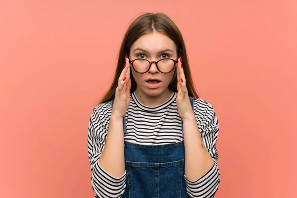 Ung Kvinna Med Overaller Över Rosa Vägg Med Glasögon Och — Stockfoto