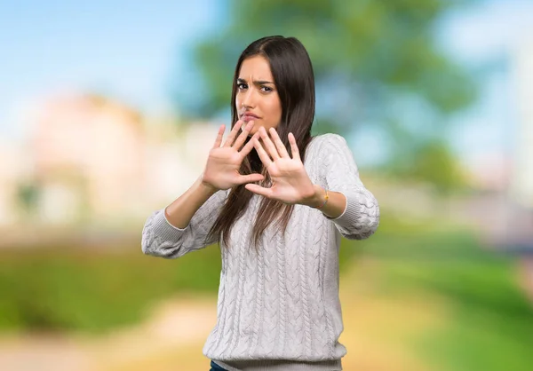 Young hispanic brunette woman nervous stretching hands to the front at outdoors