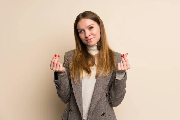 Young business woman making money gesture