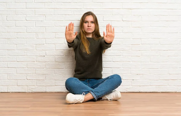 Ung Kvinna Som Sitter Golvet Gör Stopp Gesten Och Besviken — Stockfoto