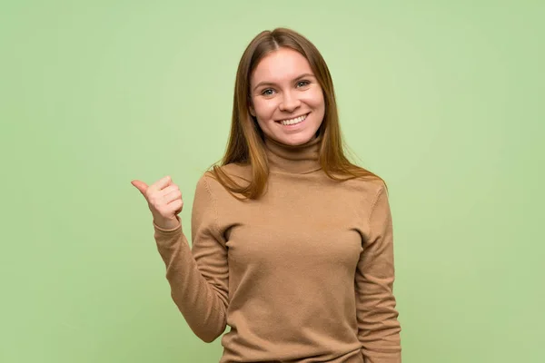 Junge Frau Mit Rollkragenpulli Die Zur Seite Zeigt Ein Produkt — Stockfoto