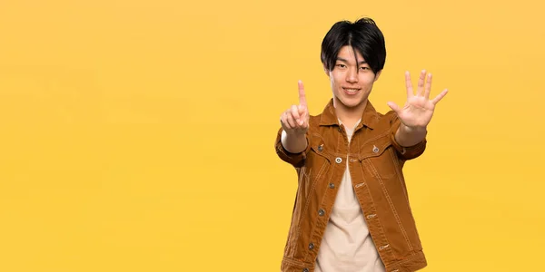 Asian Man Brown Jacket Counting Six Fingers Isolated Yellow Background — Stock Photo, Image