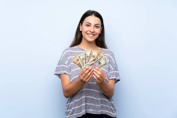 Joven Morena Sobre Aislado Fondo Azul Tomando Montón Dinero — Foto de Stock