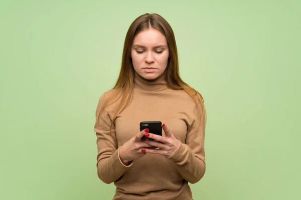 Junge Frau Mit Rollkragenpullover Sendet Eine Nachricht Mit Dem Handy — Stockfoto