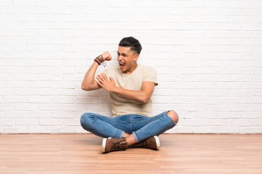 Genç adam güçlü jest yaparak katta oturan