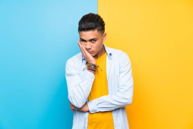 Izole renkli arka plan üzerinde Genç adam mutsuz ve sinirli