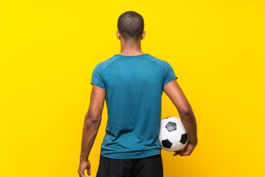 Afro Amerikan futbolcu adam izole sarı arka plan üzerinde
