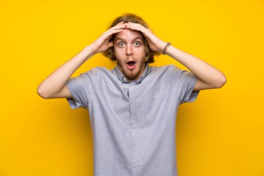 Sürpriz ifade ile izole sarı arka plan üzerinde Blonde adam