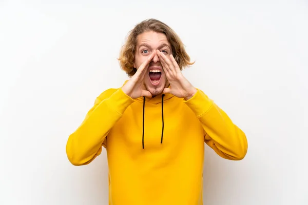 Hombre Rubio Con Sudadera Sobre Pared Blanca Gritando Anunciando Algo — Foto de Stock