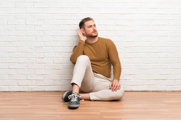 Hombre Rubio Sentado Suelo Escuchando Algo — Foto de Stock