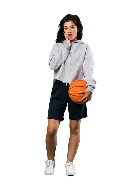 孤立した白い背景の上に驚きとショックを受けた表情でバスケットボールをしている若い女性のフルレングスショット — ストック写真
